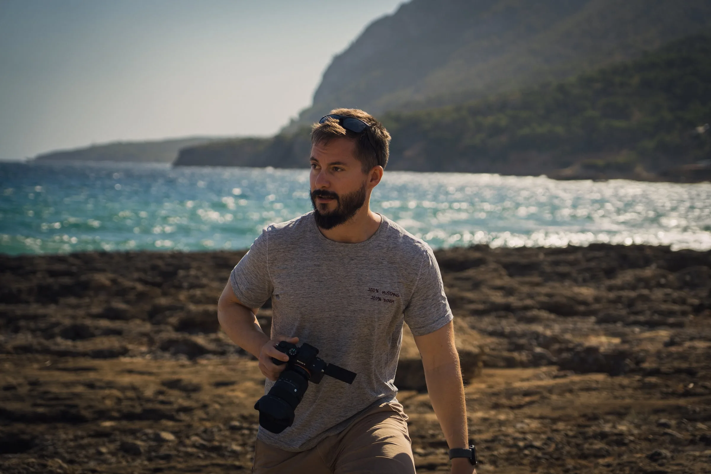 Harry Fohmann mit Sony-Kamera an einer felsigen Küste im Abendlicht