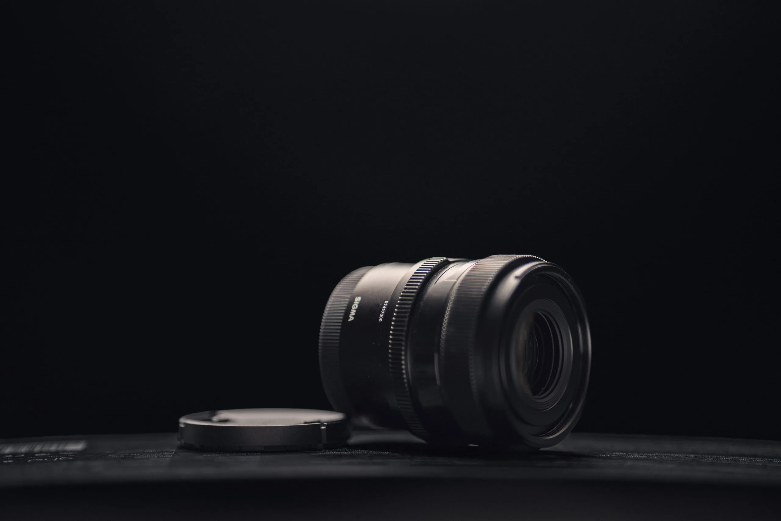 Sigma 50 mm f/2 DG DN Objektiv vor dunklem Hintergrund