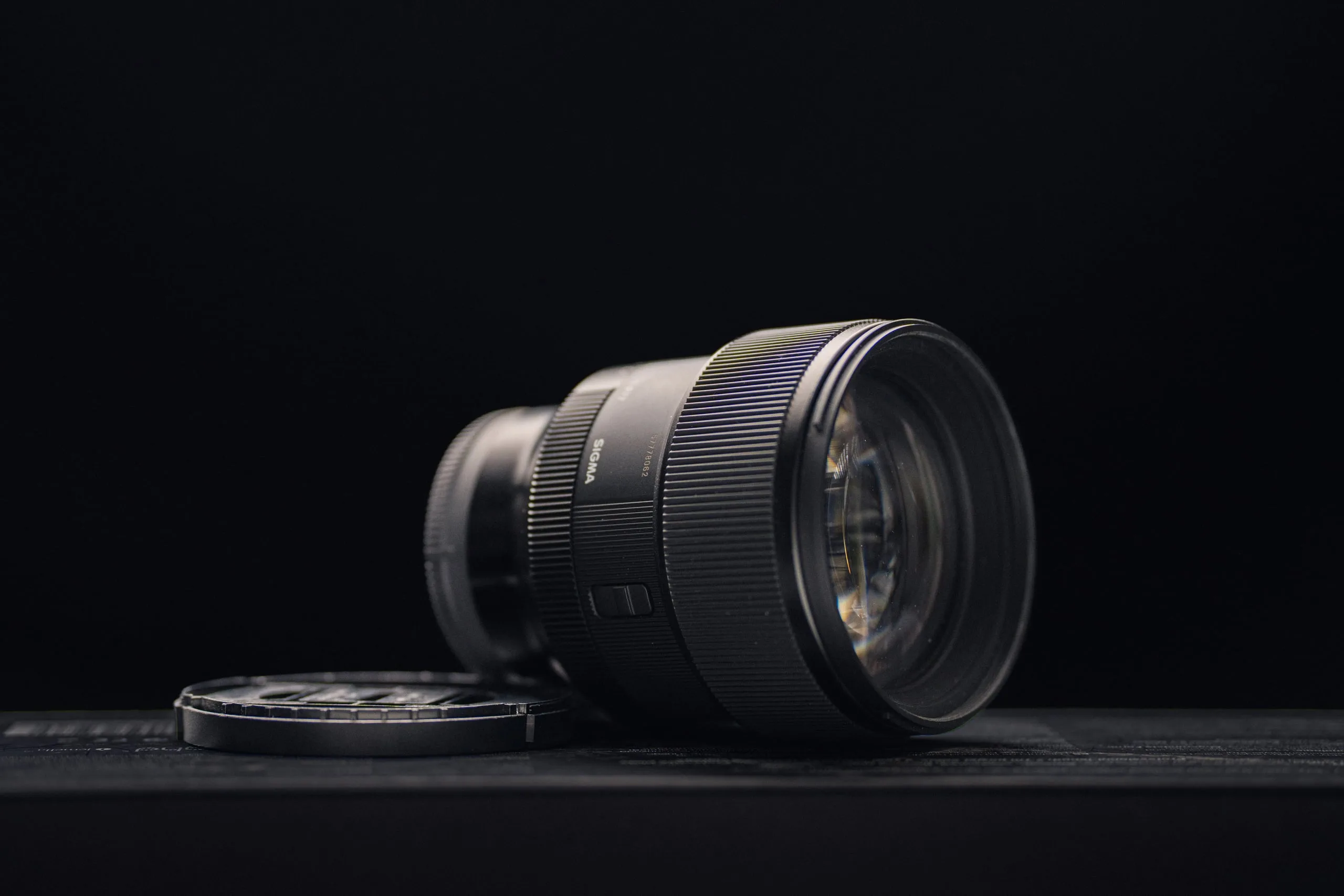 Sigma 85 mm f/1.4 DG DN Art Portraitobjektiv vor dunklem Hintergrund