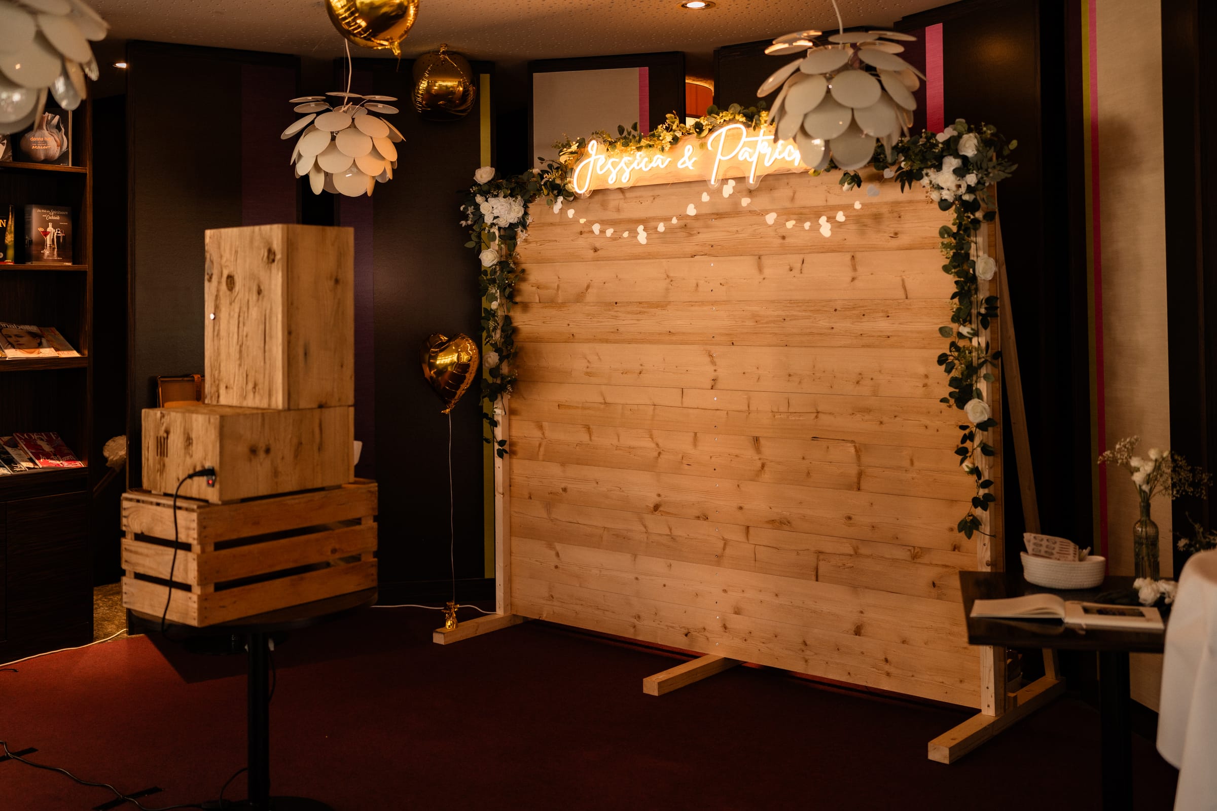 Photobooth-Ecke im B12 mit Holzwand, Neonschriftzug und Gästebuch