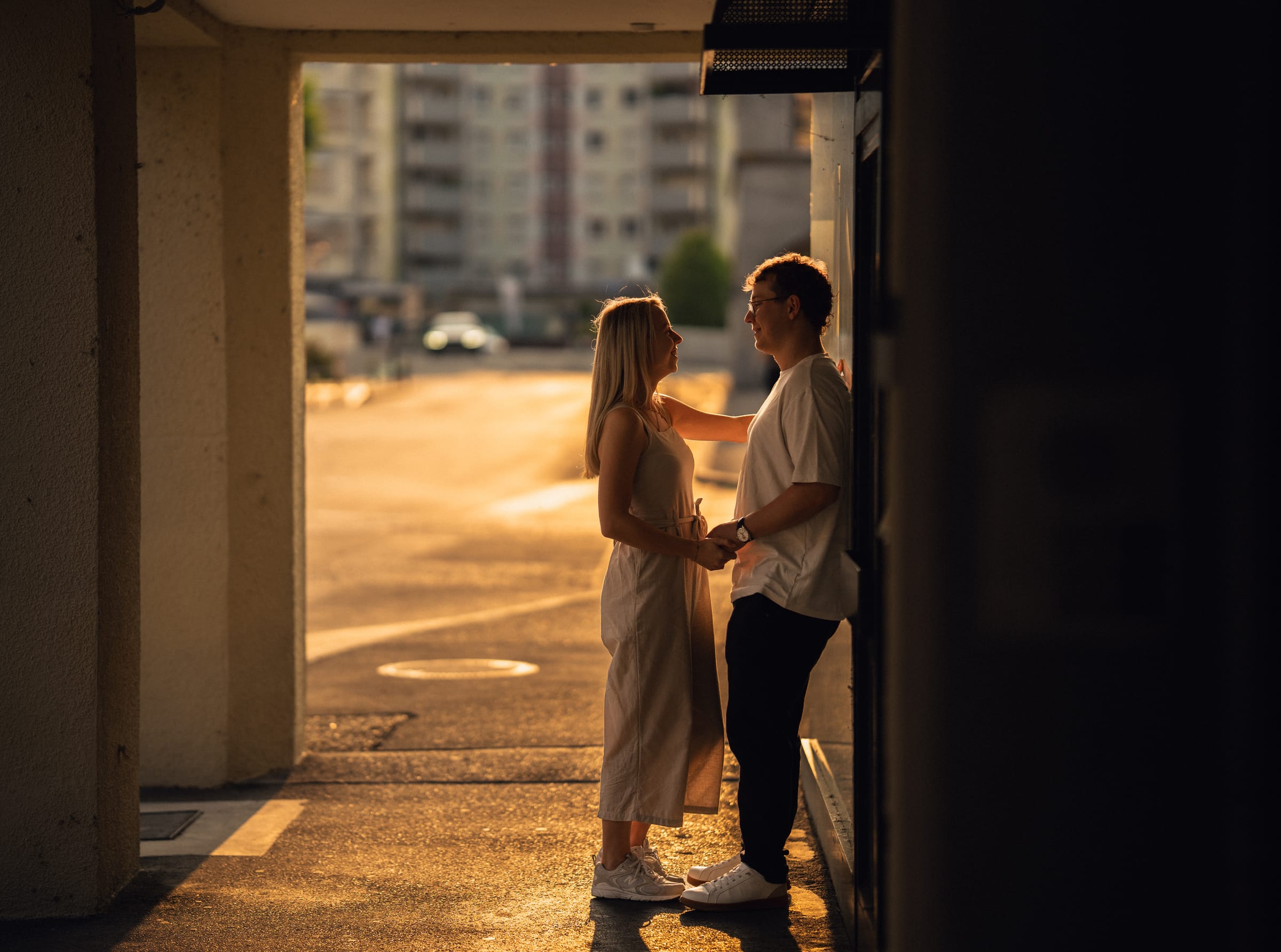 Natalie und Luca stehen sich in einem Hausdurchgang gegenüber, die Abendsonne fällt auf die Strasse dahinter
