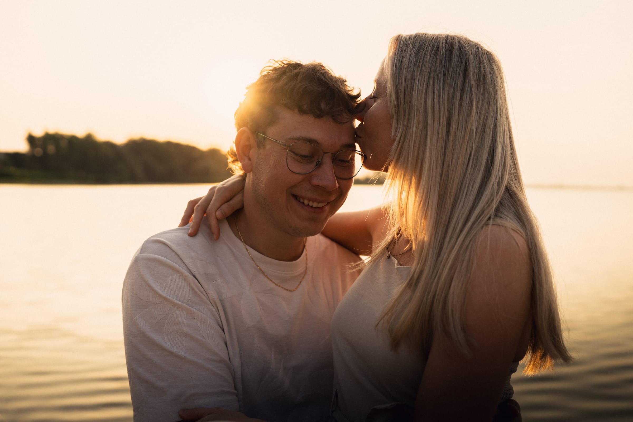 Natalie küsst Luca auf die Stirn, der Bodensee im Hintergrund leuchtet im Abendlicht