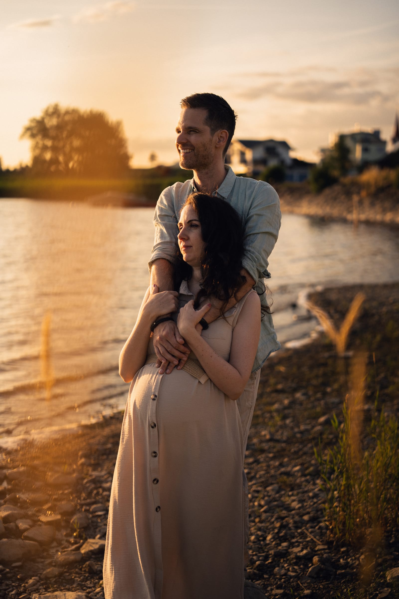 Dani hält Angelina von hinten, beide blicken über den Sihlsee in die tief stehende Sonne